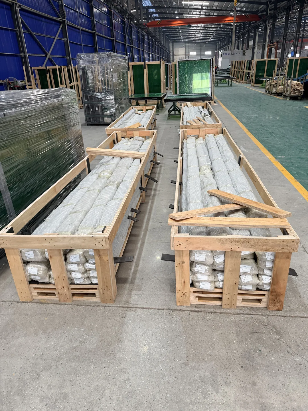 Long façade components supported and braced in timber packing frames